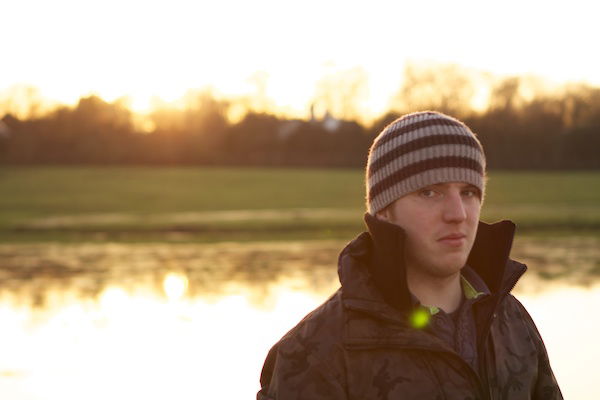 portrait of a man in a hat and coat in the sunset