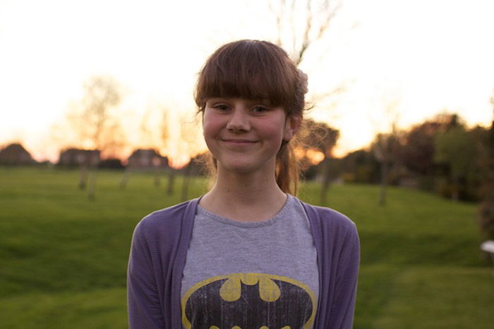 A portrait of a young girl posing outdoors