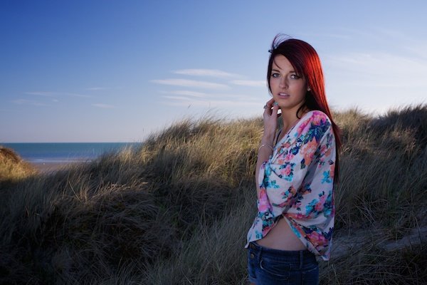A girl in a beach setting has extra light added to her portrait from the fill-in flash