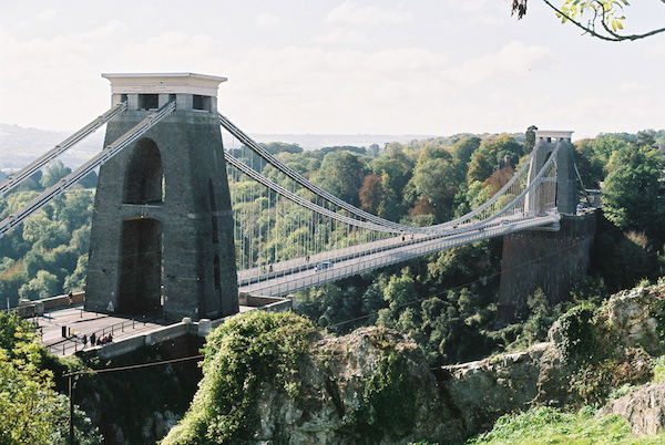 Photo of a bridge surrounded by green forest, demonstrating the use of vertical lines in photography composition