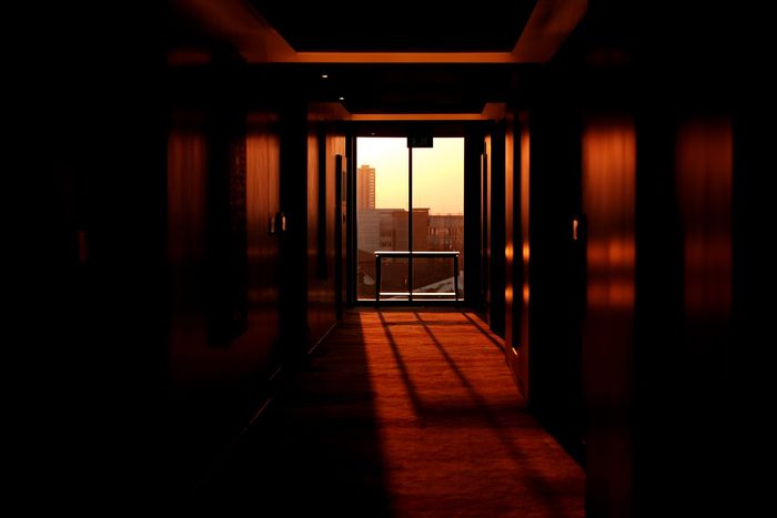 Photo of a hallway with a view from the window in the back as an example of frame within a frame for photo composition