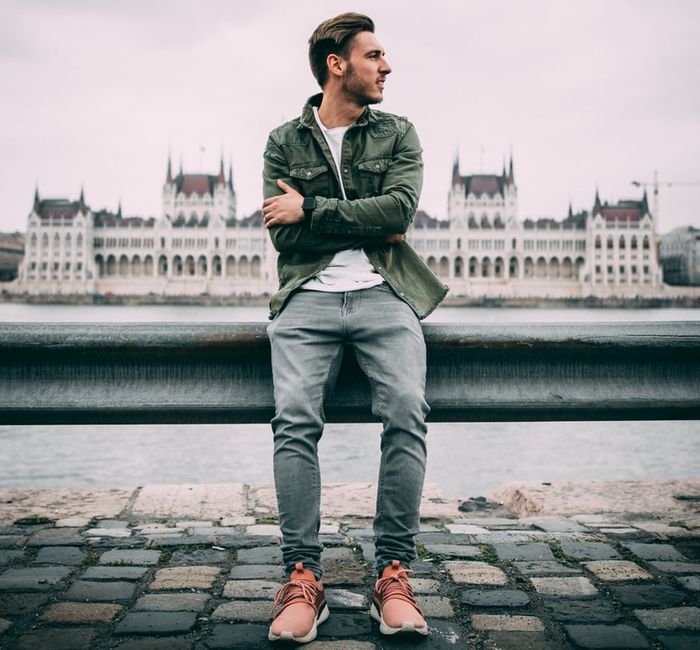 Foto de un chico con el edificio del parlamento húngaro, encuadre de fondo