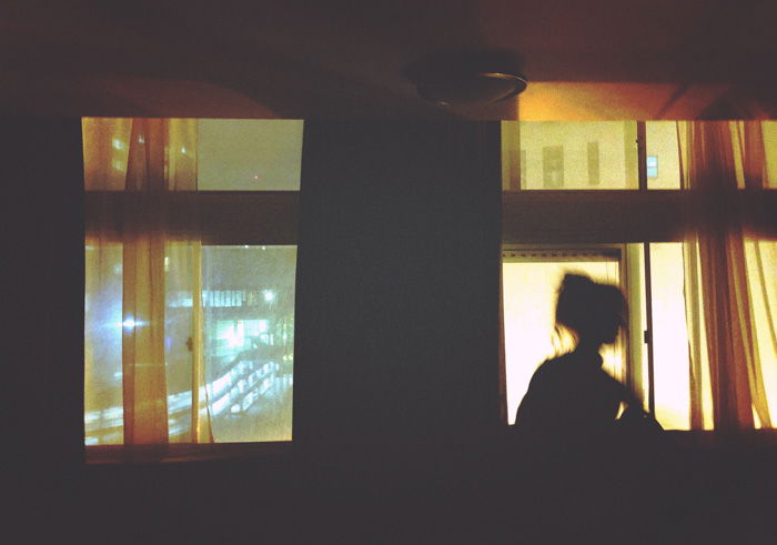 Dreamy portrait of a girl sitting on a windowsill