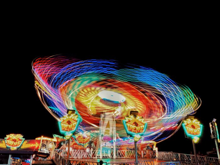 Majestic shot of the colourful lights of an amusement park ride at night