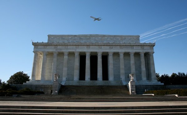 Photo of a white building with a colonnade against the blue sky