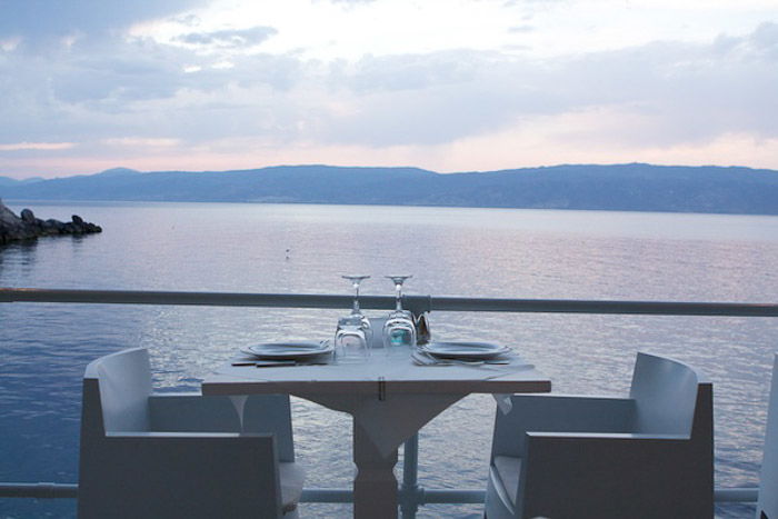 An outdoor dining table by the sea in natural light