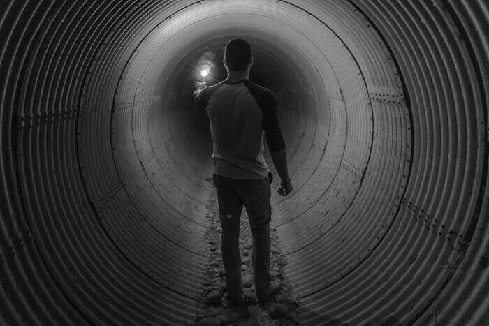 Black and white photo of a guy in a tunnel