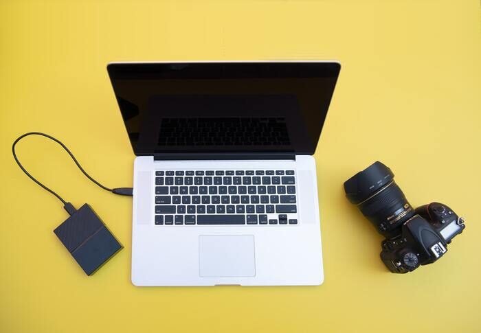 Photo of a laptop, a camera and a hard drive