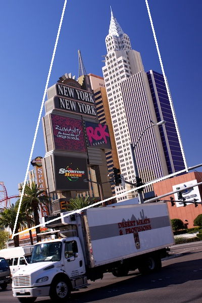 Skyscrapers in front of a busy road on a clear day, with a diagram showing the use of triangles in photography composition 