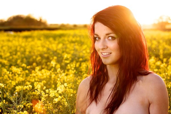 Photo of a young woman in the field of yellow flowers demonstrating editing with contrast