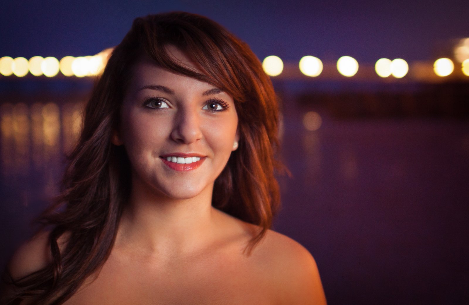 Twilight portrait lighting of a young woman with bokeh lights in the background