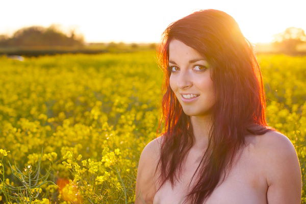 Photo of a young woman in the field of yellow flowers demonstrating editing with saturation