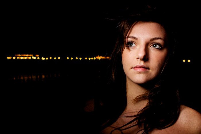 Atmospheric low key portrait of a female model at night