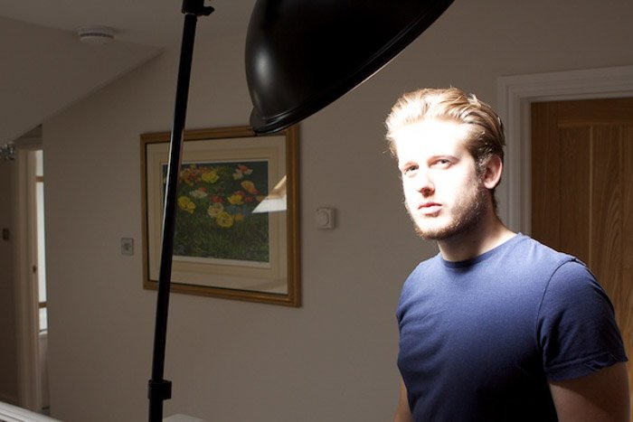 A male model posing for a photo, with low key lighting setup