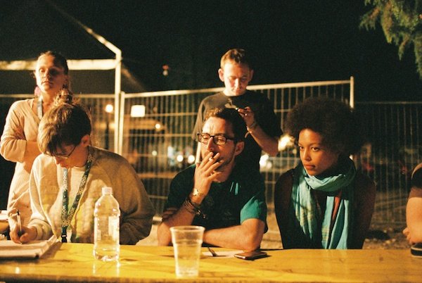 Photo of several people sitting outside in the dark