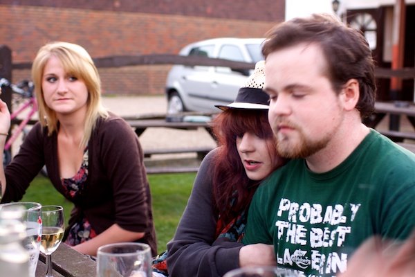 Photo of a couple and a young woman looking at them
