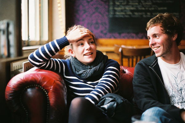 A seated couple on a sofa shot by a window for portrait lighting