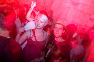 Atmospheric pink toned portrait of people in a nightclub