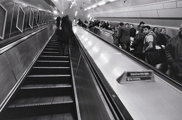 People riding the escalators in London - black and white street photography