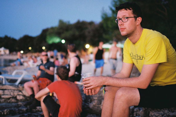 Man sitting on a beach with a beer