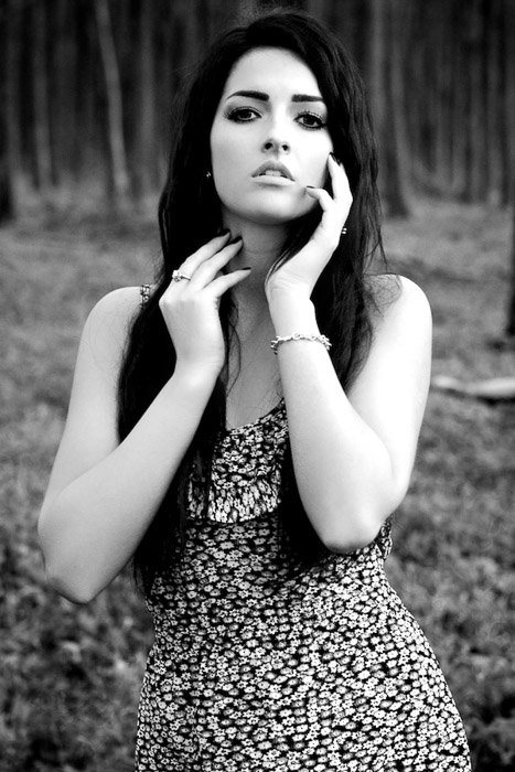 A black and white photography portrait of a female model posing outdoors
