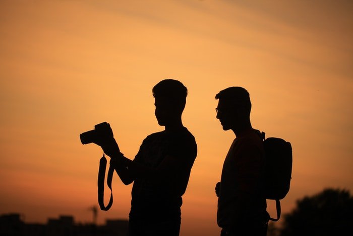 Two photographers silhouetted against the sunset 