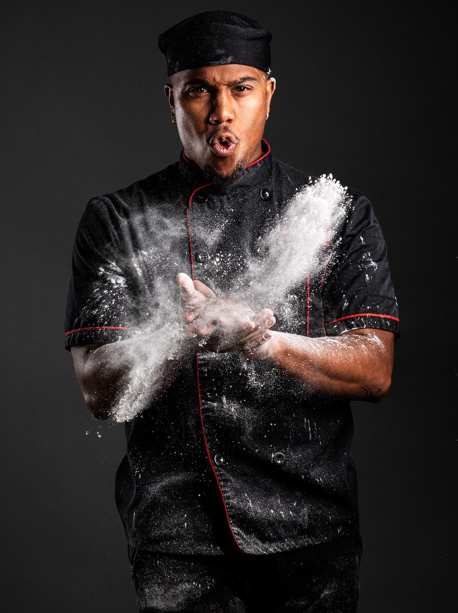 Portrait of a chef clapping his hands with flour