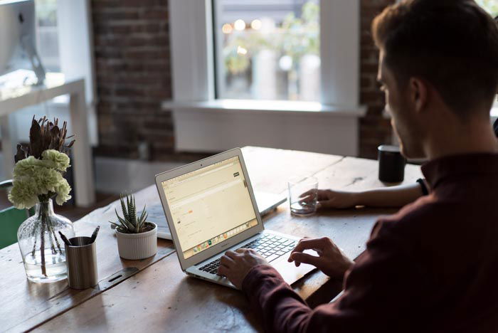 An overhead shot of a man working on his laptop