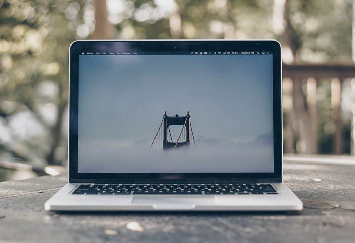 A laptop with an image of a bridge onscreen