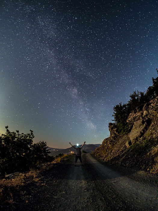 A man with outstretched arms under the Milky Way (Bobbio, Italy)