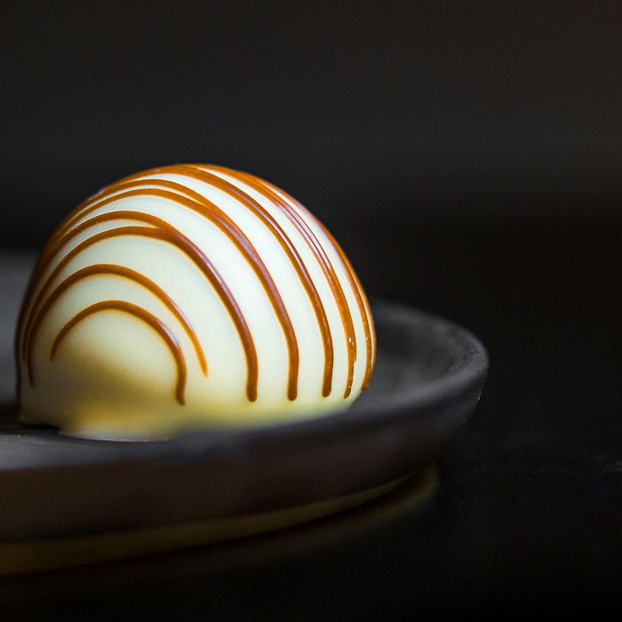 close up food photography of Belgian white chocolate decorated with caramel.