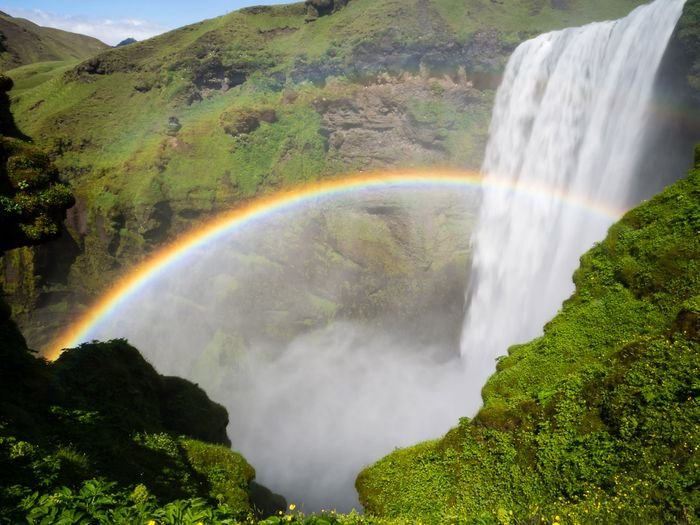 Magnificent shot of a rainbow over a waterfall 