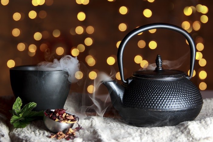 Black tea pot and mug with bokeh background