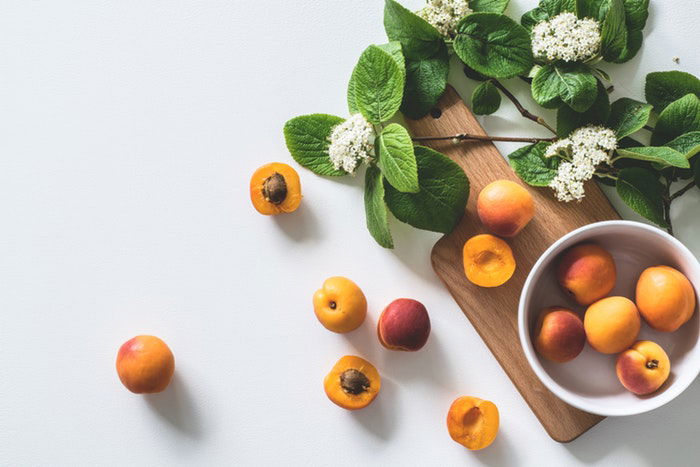 A still life photo of fruit and flowers 