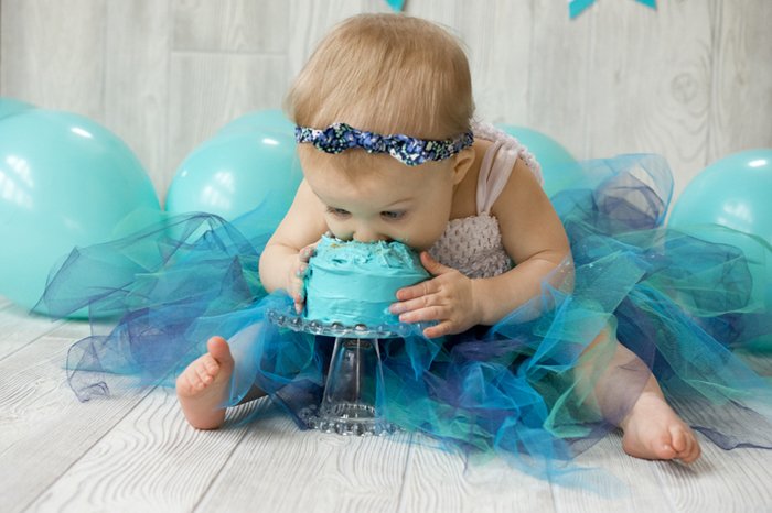 Cute diy cake smash photo shoot of a baby eating a green cake
