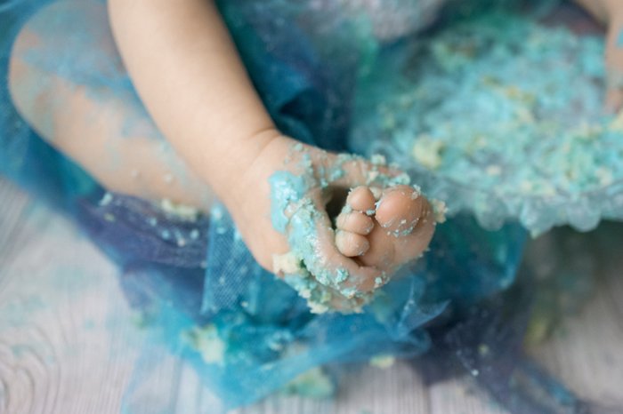 close up shot of a baby messily covered in cake during a Cute diy cake smash photoshoot