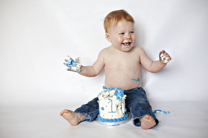 a little boy on the floor posed for cake smash photography