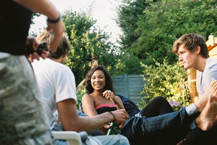 A candid portrait photo of friends chatting in a garden