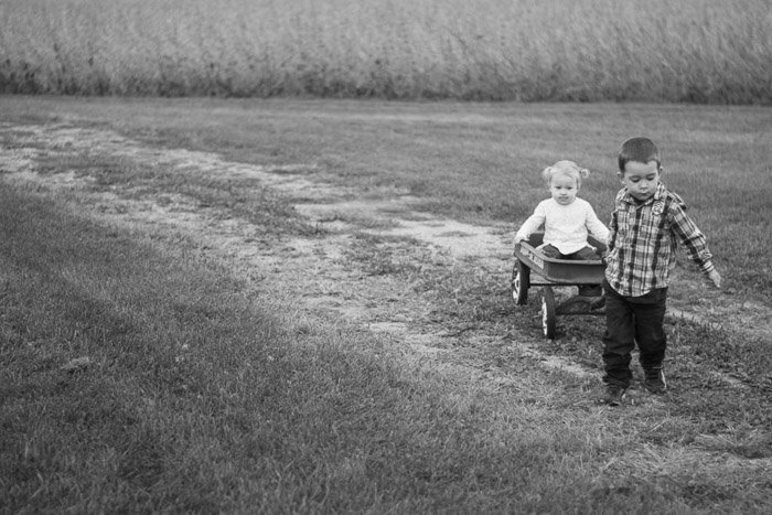 sweet and nostalgic feeling candid photo of a little boy and girl playing in fields