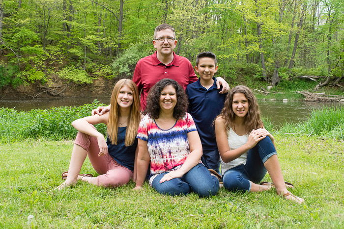 A family of 5 posing outdoors