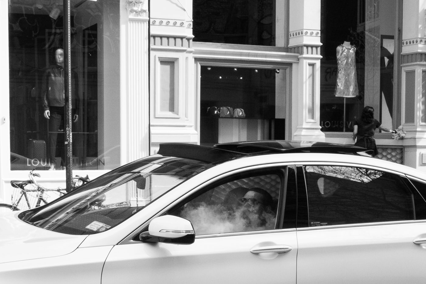 Street photography: Man smoking inside car on the street