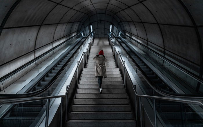 person som klättrar trappor i en tunnelbanestation