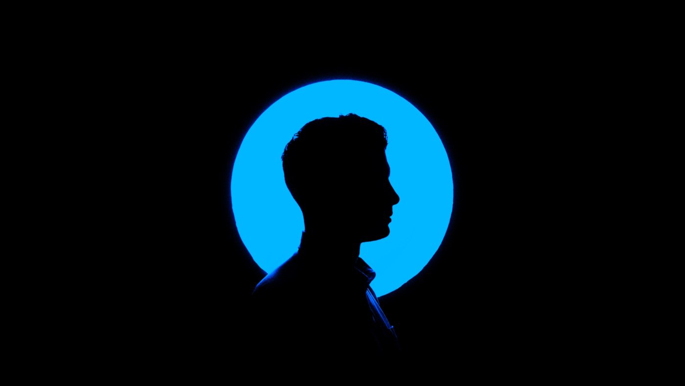 A silhouette of a person with a blue circle in the background for portrait lighting