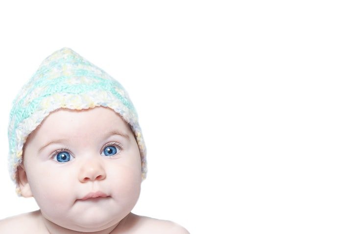High key portrait of a baby wearing hat