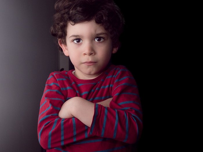 小男孩的肖像用闪光灯拍下，被白色的墙壁反射