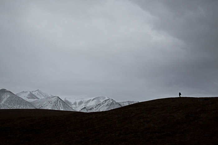 Landscape photo that appears black and white, with the silhouette of a man to the right. Picture taken over Katakturuk River.