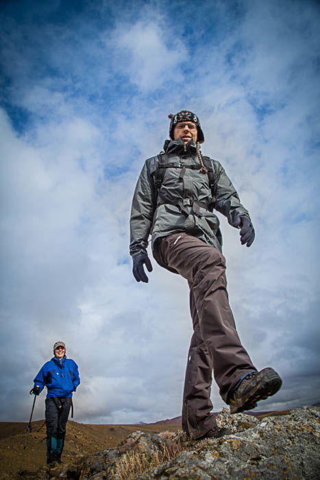 Low perspective photo of two mountain hikers with the sky in the background