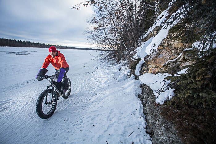 Adventure photography showing a man riding a fatbike in a winter landscape