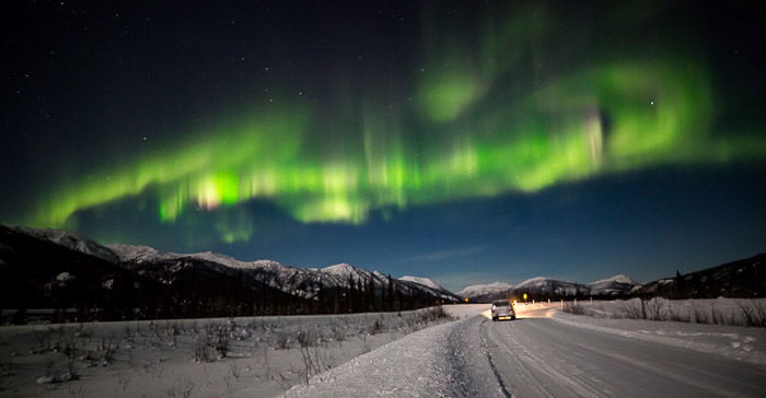 The Aurora over a settlement in the snowy fields of Alaska