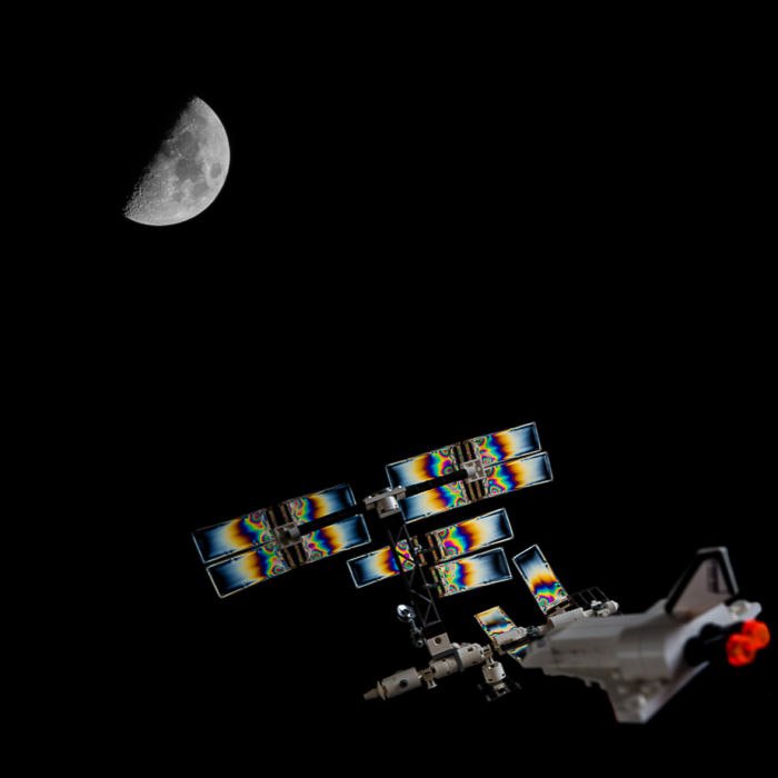A Composite image of a photoelastic LEGO space station and the Moon